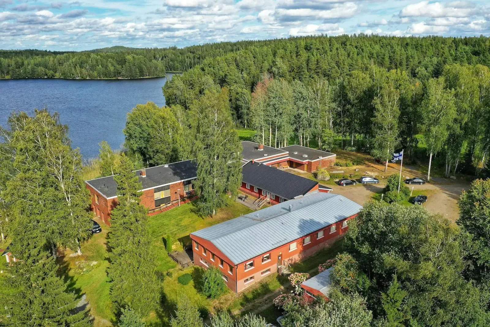 Ilmakuva Maivitan punatiilisistä rakennuksista järven rannalla
